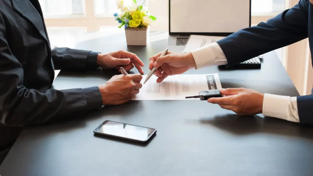 Pessoa analisando apólice de seguro para veículos com auxílio de corretor