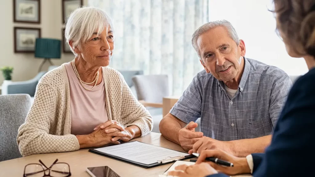 Corretor explicando opções de seguro de vida para idosos

