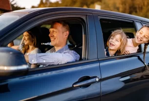 Família sorridente no carro, representando segurança com seguro para veículos