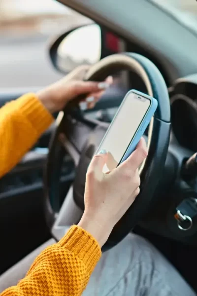 Motorista verificando seguro auto Nubank no celular dentro do carro