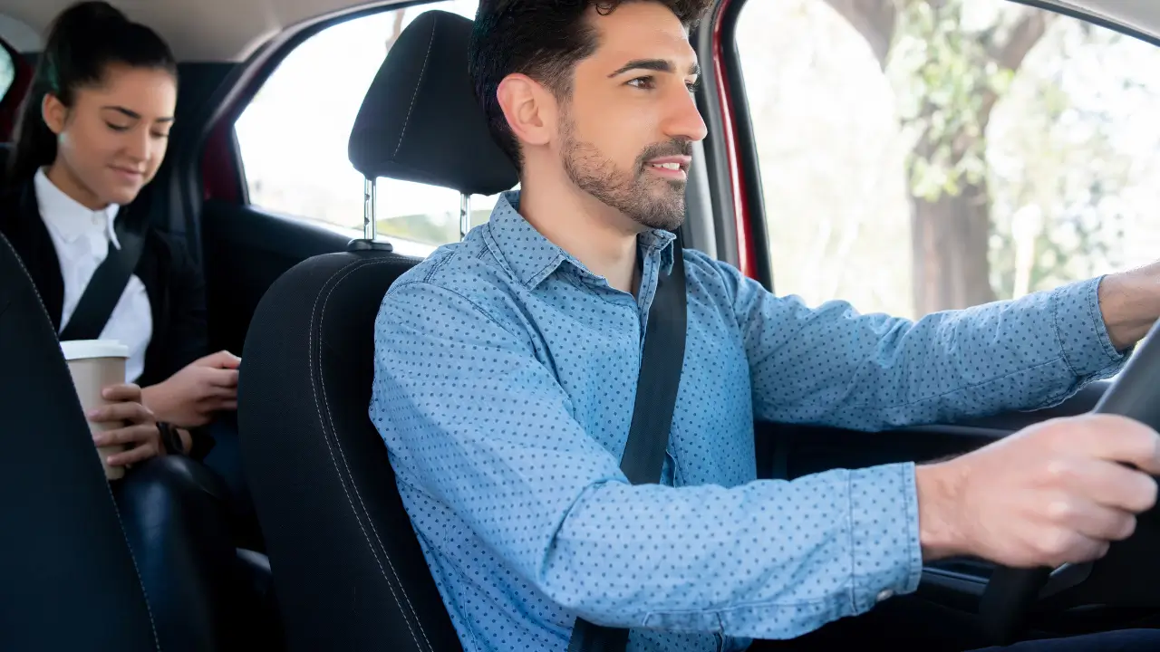 Motorista de aplicativo com passageiro protegido pelo seguro Uber.