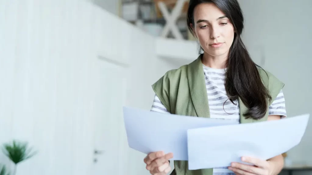 Pessoa lendo documentos de seguro prestamista em casa com tranquilidade